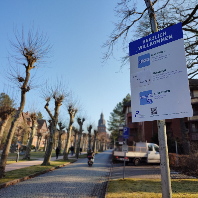 Blick auf die Allee im Evangelischen Johannesstift mit einem Hinweisschild zur Parkraumbewirtschaftung