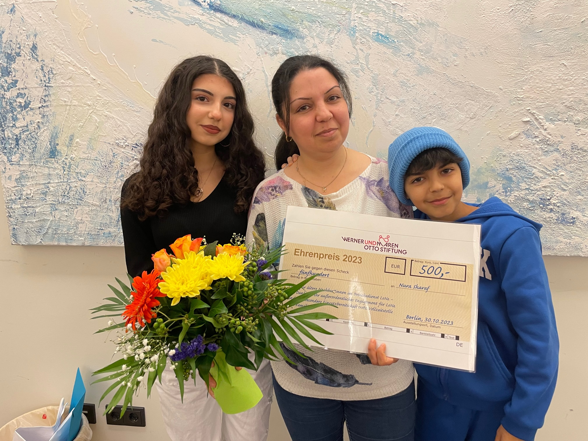 Ehrenamtspreis Blumen und Scheck für Nura Sharaf